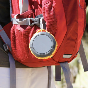 Orange and gray Omnigates Aeon Bluetooth Speaker POD clipped onto a backpack