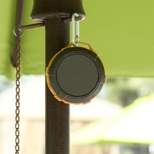 orange and gray Omnigates Aeon Bluetooth Speaker POD clipped onto a patio umbrella